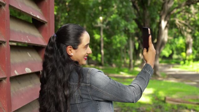 Latin woman taking picture with cell phone
