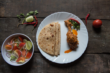 Simple North Indian meal paratha or flat bread served with spicy chicken. Top view.