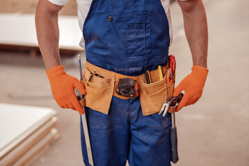 Male worker wearing tool belt with building instruments