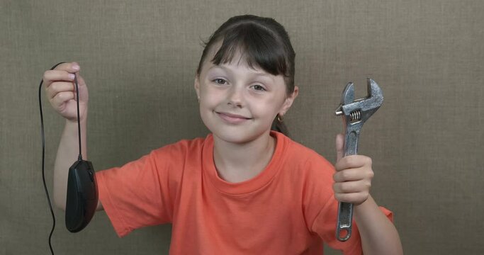 Broken computer mouse. A view of a little girl with a electric mouse and a tool in her hands in the room.