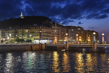 San Sebastian, Spain - 29 Aug 2021: Lights of the old town buildings reflect on the Urumea River