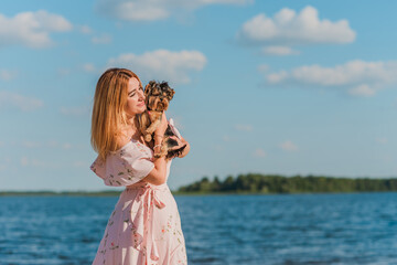 Woman with a Little fashionable luxury  Yorkshire Terrier dog at walk, pet lifestyle