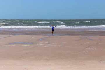 Fototapeta na wymiar The brunette woman happy on the beach. Tourism in the Delta of Parnaiba River in northeastern Brazil. Dunes and paradisiacal landscapes. Atlantic Ocean