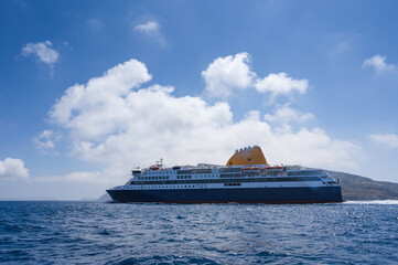 Cruise ship near Santorini island in Aegea sea, Greece. Ferry sailing to port. Transportation by...