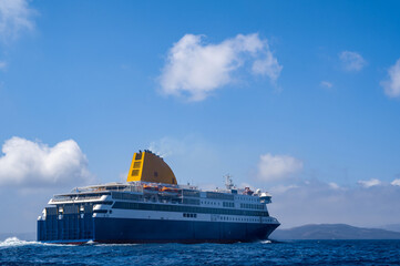 Cruise ship near Santorini island in Aegea sea, Greece. Ferry sailing to port. Transportation by...