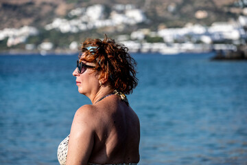 woman in red on the background of sea mountains and blue sky on the island of Crete 