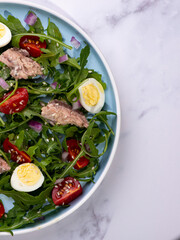 fresh salad with canned mackerel, arugula and tomatoes