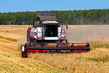 Modern combine harvester working in the field on a clear sunny day