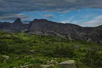 Russia. Krasnoyarsk Territory, Eastern Sayans. A group of tourists with backpacks travel through the high-mountain passes of the Ergaki natural mountain Park.