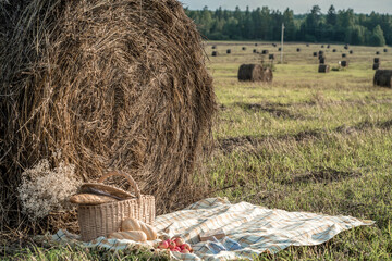 a wicker basket of bread stands next to a haystack