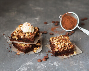 American cuisine. Brownies with ice cream. Chocolate cake with hazelnuts. Square cakes with nuts. Cocoa and chocolate drops.
