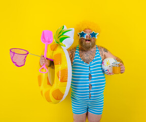 Fat happy man with wig in head is ready to swim with a donut lifesaver