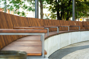 A long curved wooden bench in a city park