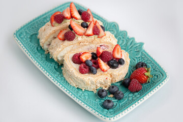 Delicious confectionery with berries on a blue beautiful plate
