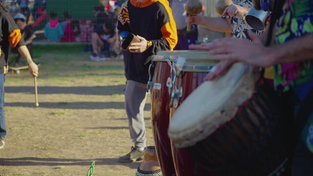 Percussion band playing in the park
On a sunny day, a band plays in the park, we see with a soft blur the hands of the musicians beating the drums