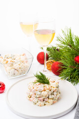 Traditional New Year's salad olivier with festive decorations on a white background