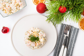 Traditional New Year's salad olivier with festive decorations on a white background