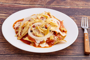 Chilaquiles rojos con pollo, comida tradicional mexicana en el desayuno o comida