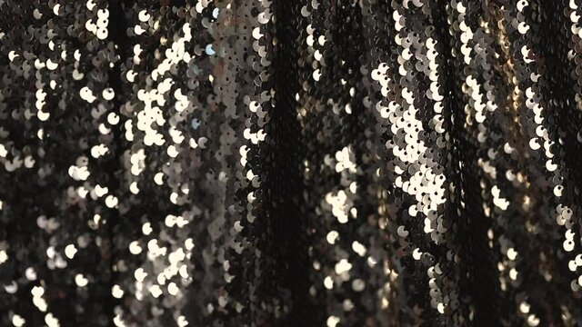 abstract background with a dress made of fabric with sequins close-up beautifully glitters and shimmers in motion