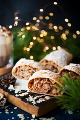 Homemade Christmas dessert, apple strudel, cake on the festive table with garlands