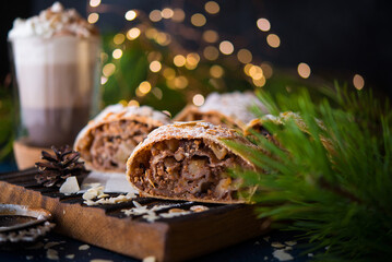 Homemade Christmas dessert, apple strudel, cake on the festive table with garlands