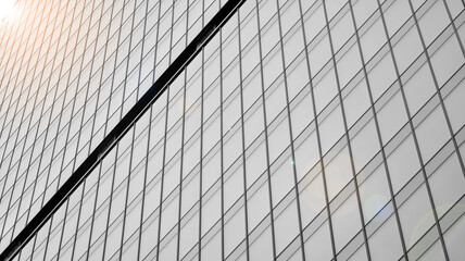 Modern architectural details. Modern glass facade with a geometric pattern. Contemporary corporate business architecture. Red sun on horizon. Black and white toned image.