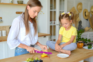 mom and daughter cook healthy food together in the kitchen. healthy food and lifestyle concept