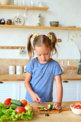 portrait of a little cute girl in the kitchen with groceries and healthy food