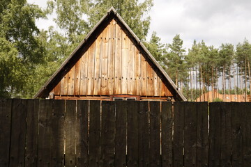 Chata drewniana rustykalna za płotem drewnianym latem