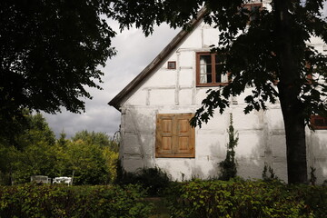 Dom biały ze spadzistym dachem i drewnianymi framugami