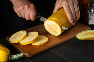 The chef cuts ripe yellow marrow with a knife. Fried zucchini is a great diet for breakfast or lunch. Work environment on the kitchen table of the restaurant