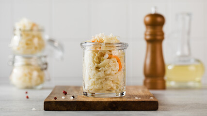 Fototapeta na wymiar Sauerkraut in glass jars. Fermentation and canning of vegetables.