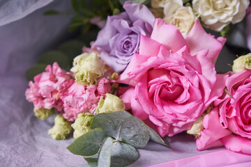 Close-up of a colorful bouquet of flowers. Big pink roses. On a light background, top view, copy space. High quality photo