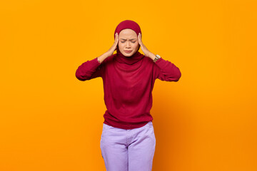 Beautiful Asian woman holding her temples, having a headache, with her eyes closed