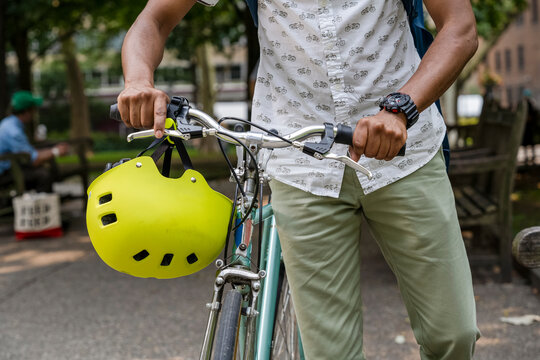 Man with bicycle in park, mid section