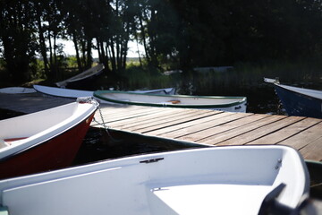 Łódki przy pomoście drewnianym nad jeziorem - obrazy, fototapety, plakaty