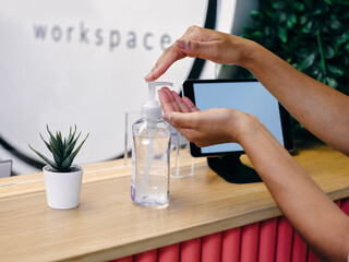 Woman using soap dispenser, close up of hands