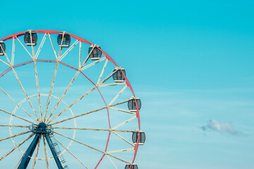 Ferris wheel against the background of the cloudy sky. Close-up photo