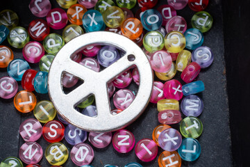 Top view of colorful Latin letters and a peace sign on a box