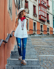 A middle-aged tourist wearing a hat strolls through an old quarter in Bilbao, Spain. Travel concept.