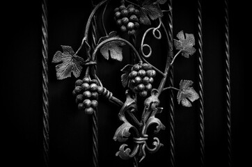 Decorative decoration of a metal fence with forged elements. Bunch of grapes