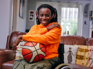 Girl in wheelchair holding basketball
