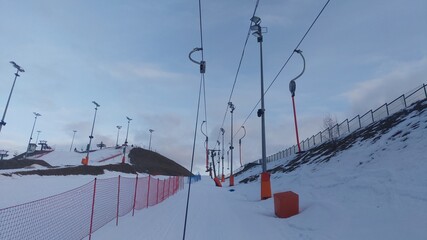 The ski center has a rope lift, and the slopes are equipped with a mesh fence and poles with lighting lamps.