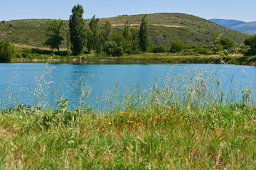 A beautiful blue lake with several trees on its shores.