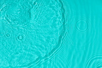 Fototapeta na wymiar Water tranquil ripple background. Water texture, circles and bubbles on a liquid blue surface. Cosmetic products and flat design concept