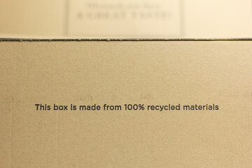 Closeup of a carboard box saying “This box is made from 100% recycled materials”. 