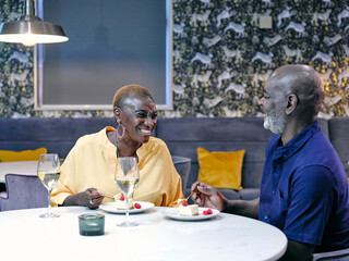 UK, Mature couple enjoying desserts at restaurant table