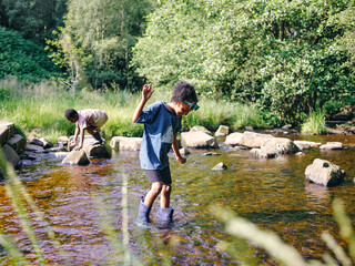UK, Children playing in shallow creek