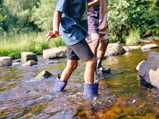 UK, Children wading in shallow creek - obrazy, fototapety, plakaty