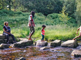 UK, Family playing in shallow creek